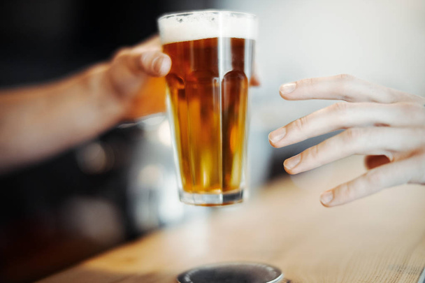 Bartender man gives beer glass to a customer. - Foto, Bild