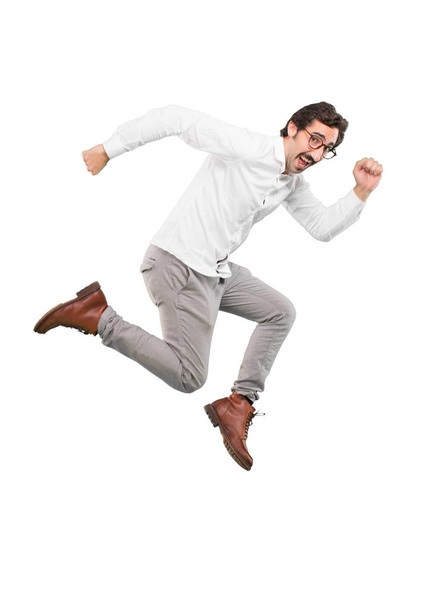 Young crazy man jumping. Full body cutout person against white background. - Valokuva, kuva