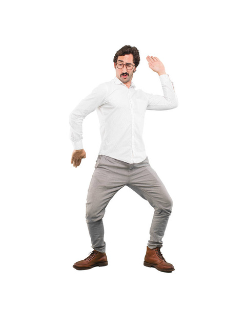Young crazy man dancing. Full body cutout person against white background. - Фото, изображение