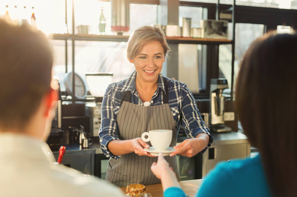 Досвідчений усміхнений бариста робить каву клієнтам
 - Фото, зображення