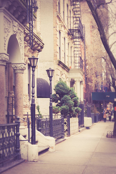 Vintage looking New York City Manhattan street scene from sidewalk with pretty apartment building with railing and lamp post. - Photo, Image