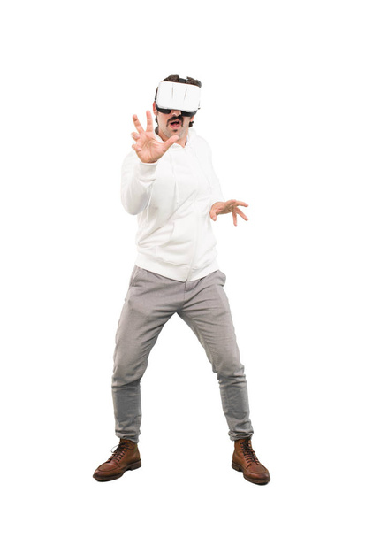 Nuori hullu, jolla on virtuaalitodellisuuslasit. Koko kehon katkaisuhenkilö valkoista taustaa vasten
. - Valokuva, kuva