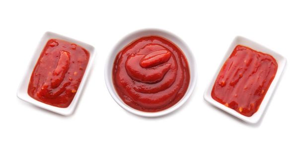 Tigelas com deliciosos molhos de tomate no fundo branco
 - Foto, Imagem