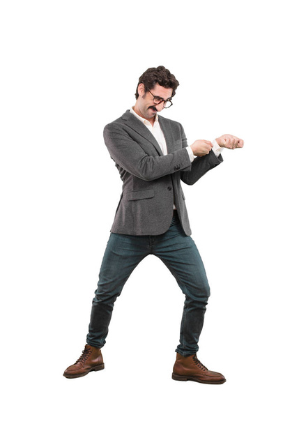 Young crazy man pulling sign with an empty copyspace to place your concept. Full body cutout person against white background. - Foto, afbeelding