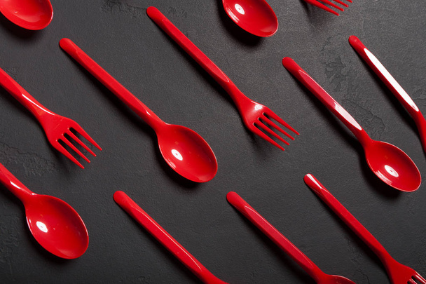 Vista dall'alto su forchette e cucchiai di plastica su sfondo nero
 - Foto, immagini