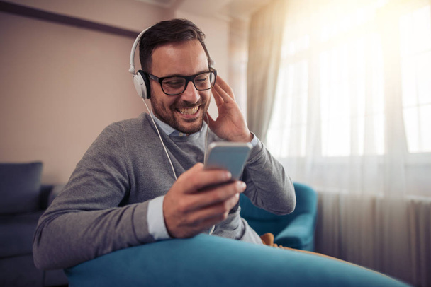 Happy young man with headphones.Listening to music at home. - Foto, Imagen