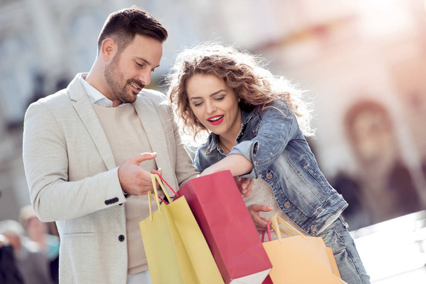 Porträt eines glücklichen Paares mit Einkaufstüten. Verkauf, Konsum und Menschenkonzept. - Foto, Bild