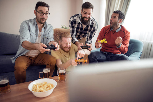Група друзів, які грають у відеоігри вдома разом
. - Фото, зображення