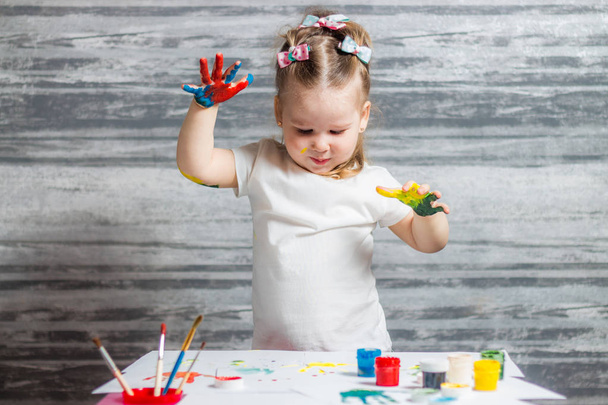 Little girl is drawing colors. Hands of girl is decorated of colors. - Fotoğraf, Görsel