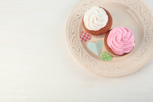Prato com deliciosos cupcakes na mesa. Celebração do Dia das Mães
 - Foto, Imagem