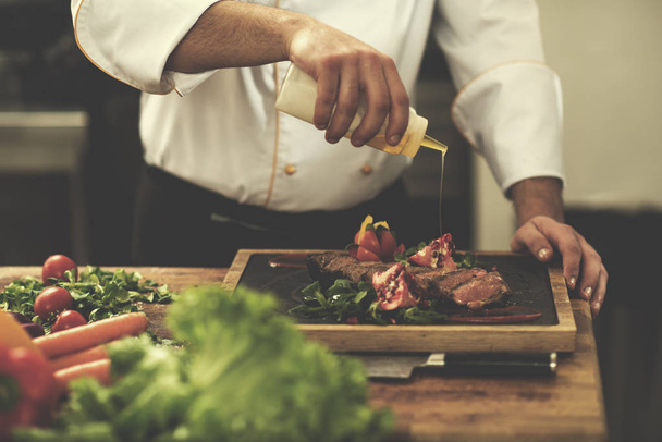 Chef finishing steak meat plate - Фото, изображение