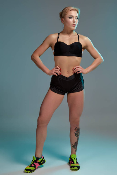 Fitness woman in black tank top and shorts, studio shot. - Zdjęcie, obraz