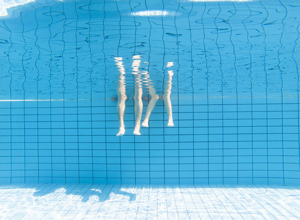 padre e hijo pies bajo el agua en la piscina
 - Foto, Imagen