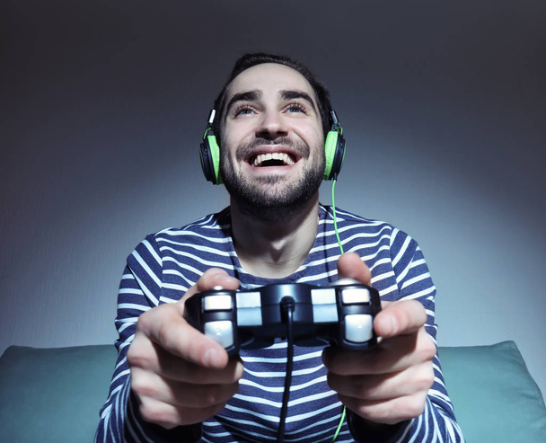Młody człowiek gra w gry wideo w domu - Zdjęcie, obraz