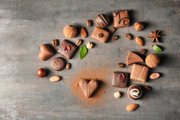 Σύνθεση με διαφορετικές γευστικές καραμέλες από σοκολάτα σε φόντο με υφή - Φωτογραφία, εικόνα
