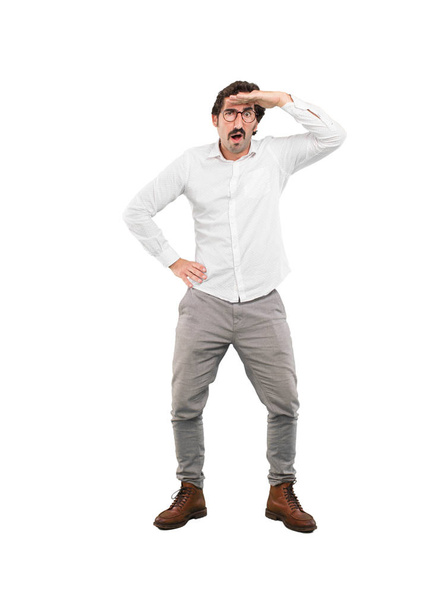 Young crazy man looking far sign. Full body cutout person against white background. - Foto, Imagem