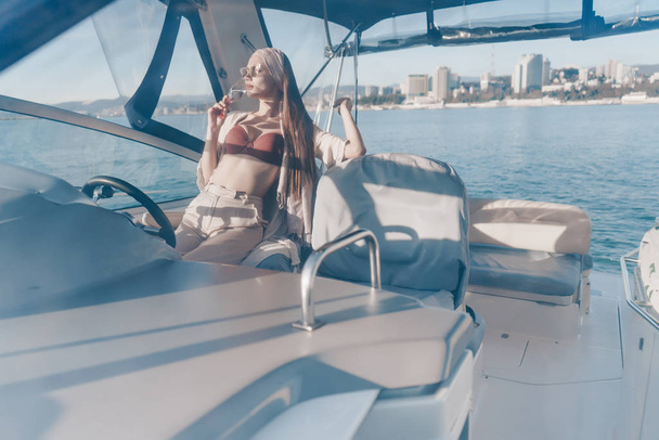 a luxurious rich woman in sunglasses rests and relaxes on her yacht, sails to the islands - Foto, Imagem
