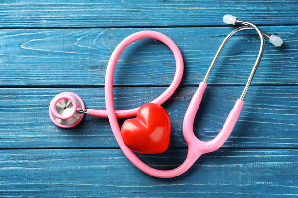 Stetoskop z czerwonym sercem na podłoże drewniane. Pojęcie opieki zdrowotnej - Zdjęcie, obraz