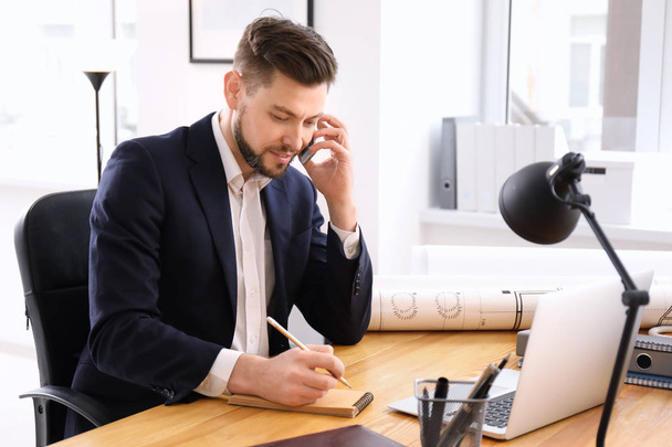 Üzletember beszél telefonon az irodai munka közben - Fotó, kép