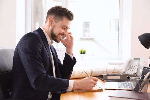 Empresario hablando por teléfono mientras trabaja en la oficina
 - Foto, Imagen