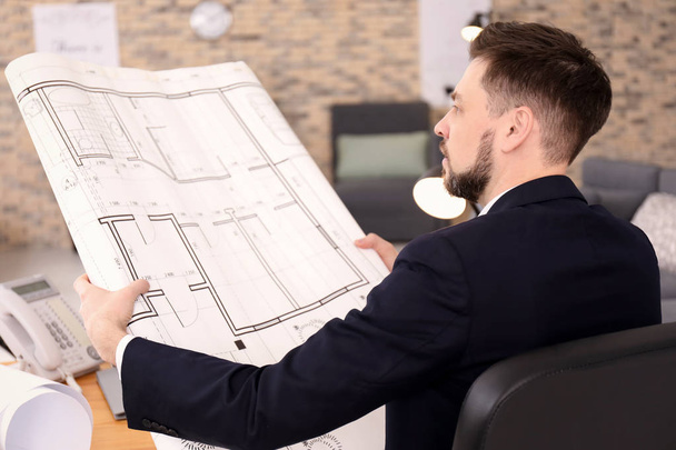 Architect with floor plan in office - Photo, image