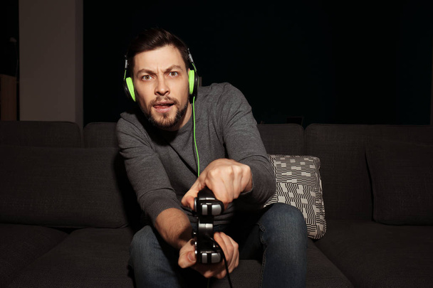 Tunteellinen mies pelaa videopeliä kotona
 - Valokuva, kuva