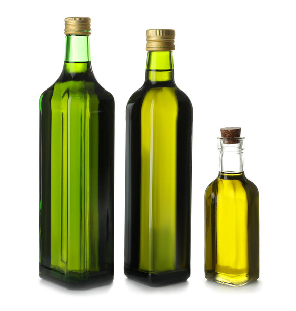 Glazen flessen met olijfolie op witte achtergrond - Foto, afbeelding