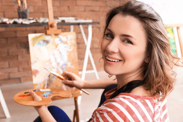 Vrouwelijke kunstenaar in workshop schilderen - Foto, afbeelding