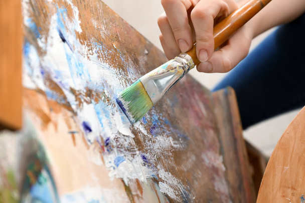 Female artist painting in workshop, closeup - Foto, afbeelding