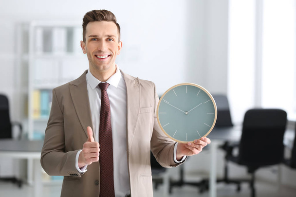 Successful businessman with clock in office. Time management concept - Photo, Image