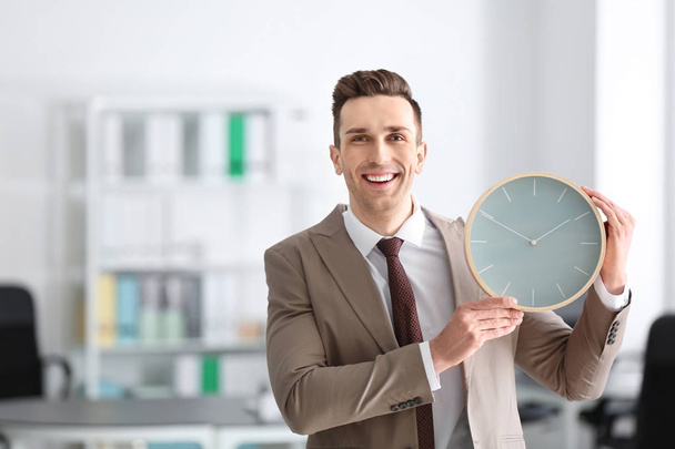 Homme d'affaires prospère avec horloge au bureau. Concept de gestion du temps
 - Photo, image