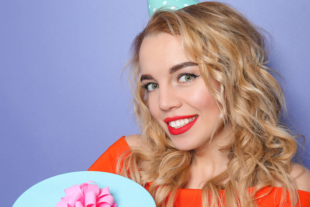 Ritratto di bella giovane donna con regalo di compleanno su sfondo a colori
 - Foto, immagini