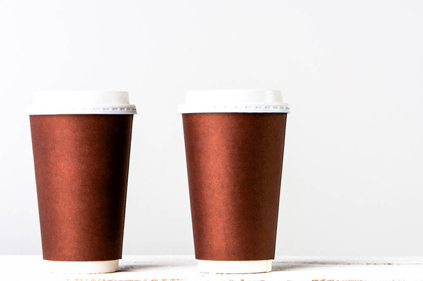 Tasse à café à emporter isolé. Tasses jetables avec du papier en brun
. - Photo, image