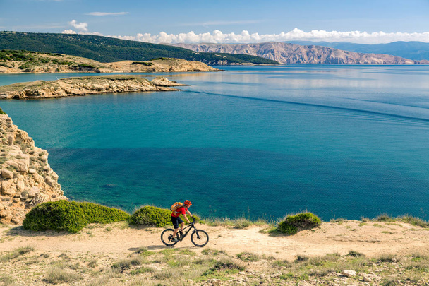 Manzaraya bakarak ve yaz deniz manzara modunda bisikletle seyahat Mountainbiker. Adam binici MTB kayalık sarı yolda Bisiklete binme. Fitness motivasyon, güzel ilham verici manzara ilham. - Fotoğraf, Görsel