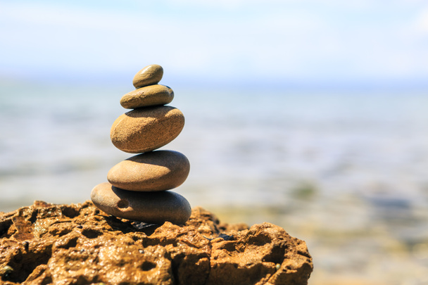 Steine Balance und Wellness Retro-Spa-Konzept, Inspiration, Zen-like und Wohlbefinden ruhige Komposition. Nahaufnahme weißer Kieselsteine über blauem Meer - Foto, Bild