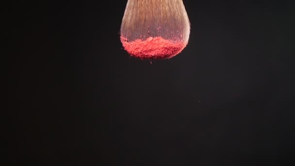 Powderbrush on black background with pink powder - Filmati, video