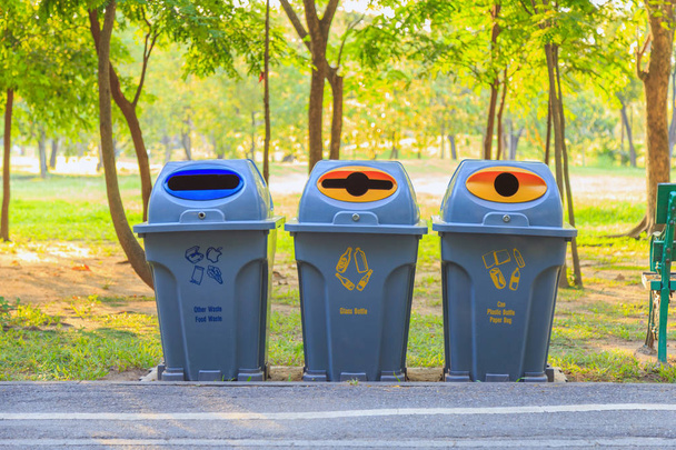 Drei Mülltonnen für die Mülltrennung entlang des Weges im Park . - Foto, Bild