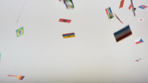 latający międzynarodowych flagi świata na białym tle. Kamera jest nieruchoma - Materiał filmowy, wideo