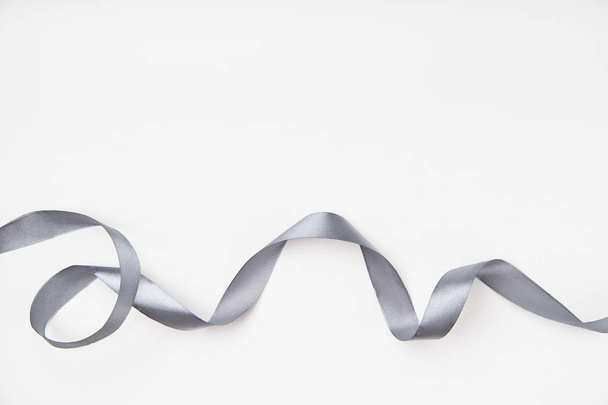 curled gray silk ribbon on white background with copy space - Fotó, kép