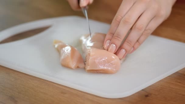 Female hand cut a piece of chicken fillet - Footage, Video