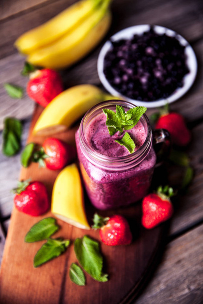 Blueberry smoothies on a wooden background with fruits. Vitamins - Foto, Bild