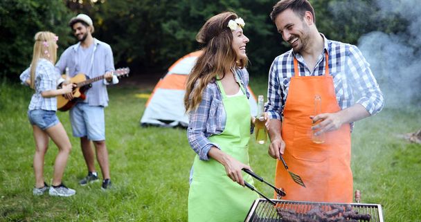 Cheerful friends spending time in nature and having barbecue - 写真・画像
