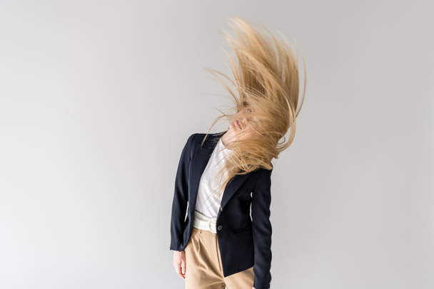 beautiful stylish blonde girl shaking hair isolated on grey - Fotó, kép