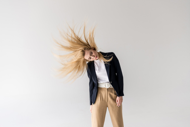 piękna młoda kobieta Blondynki drżenie włosów na szarym tle - Zdjęcie, obraz