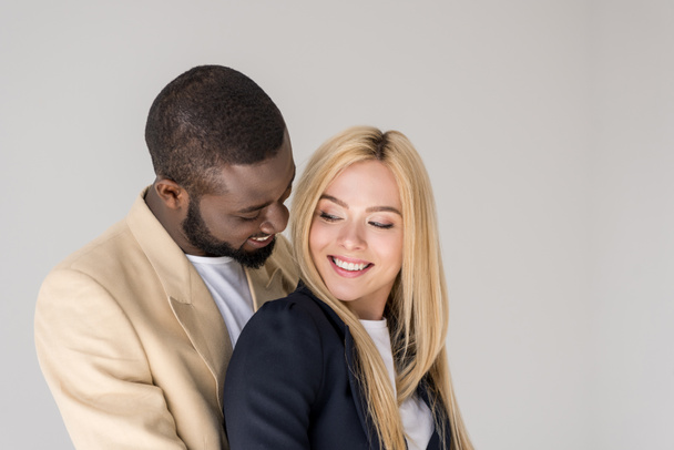 portrait of beautiful happy young multiethnic couple posing together isolated on grey - Fotó, kép