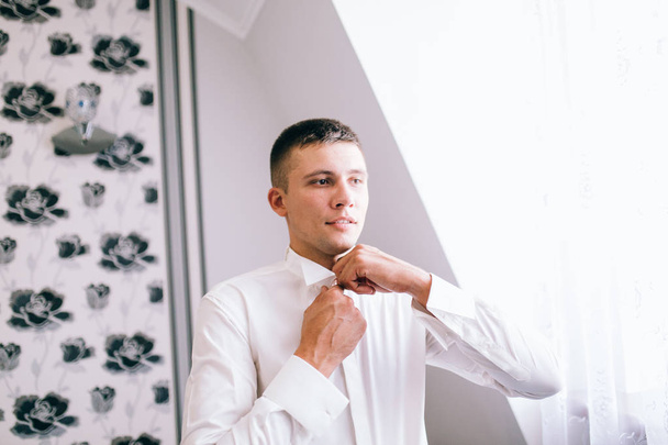 young handsome  man getting dressed  indoors - Valokuva, kuva