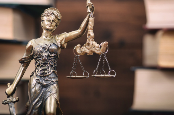 Scales of Justice, Justitia, Lady Justice and Law books in the background. - Photo, Image