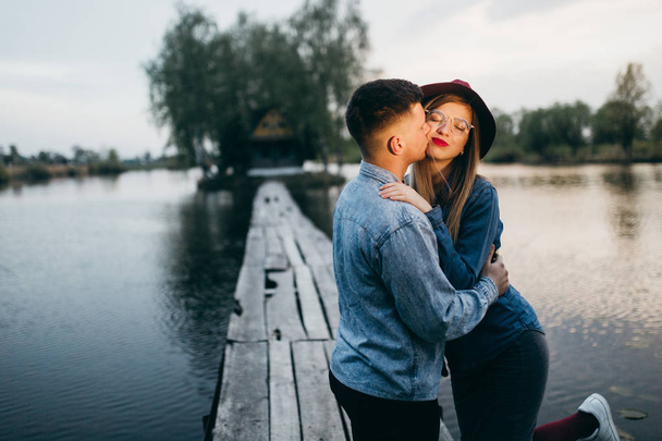 Fashion couple kissing on  the bridge - Photo, Image