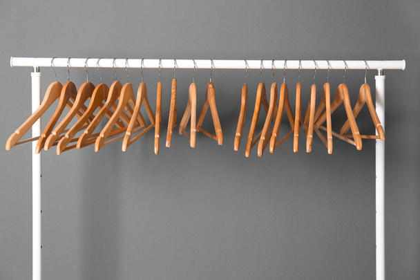 Clothes rail with wooden hangers on gray background - Foto, immagini