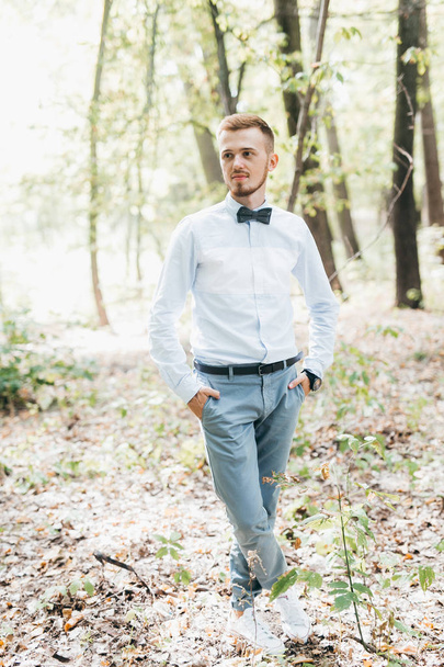 handsome  young groom  posing in park - Valokuva, kuva
